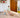 Toddler playing on a wooden Pikler Triangle with a climbing ramp in a bright, modern living room.