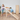 Two young children playing on a wooden Montessori climbing arch with colourful pastel rungs and an attached ramp, one child climbing up while the other stands nearby smiling.
